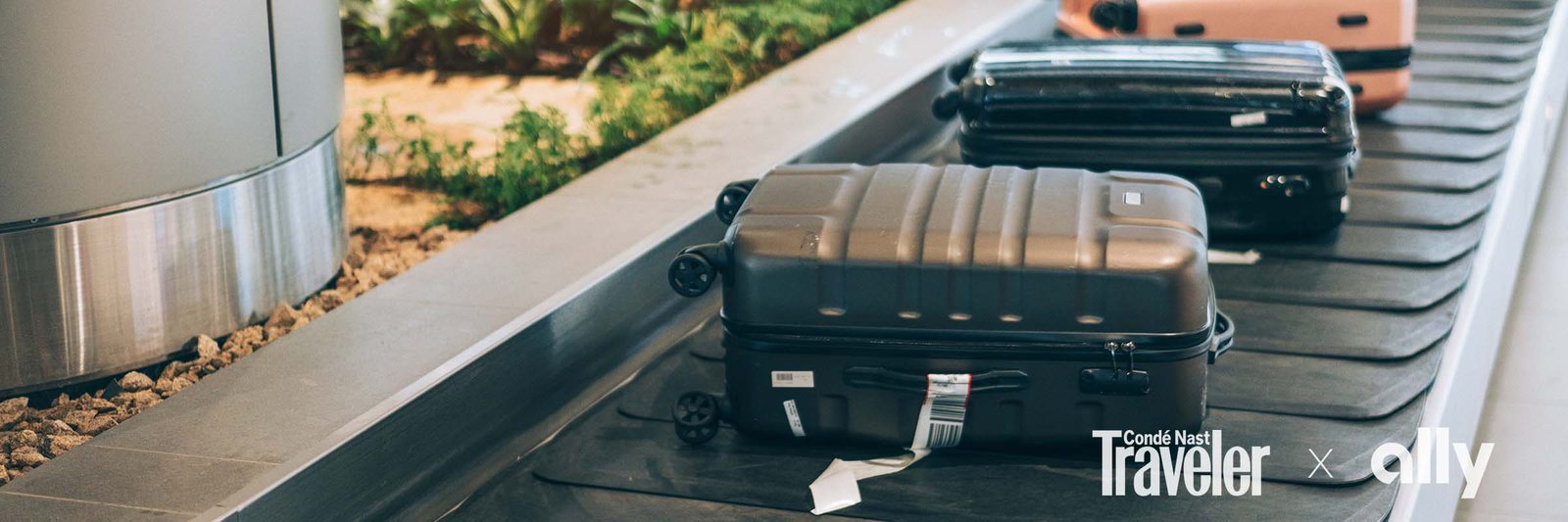Suitcases on an airport baggage carousel, representing extra travel costs