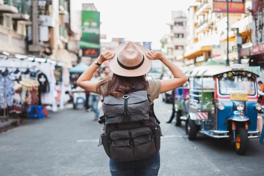 Traveler walking through a train station with luggage, symbolizing frequent transit costs