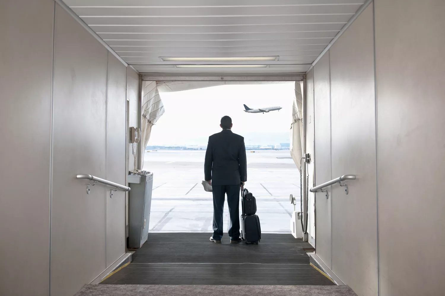 Hispanic businessman standing on jetway