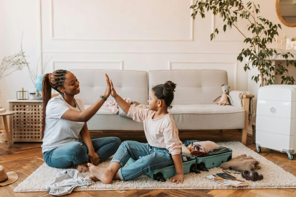 Mother and daughter doing high five after packing for trip.