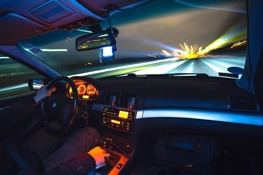 Car driving on an open road, illustrating a road trip