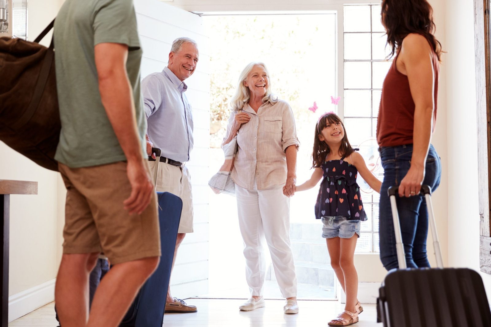Family at their front door preparing to leave for a holiday, symbolizing planning and packing smart before heading to the airport
