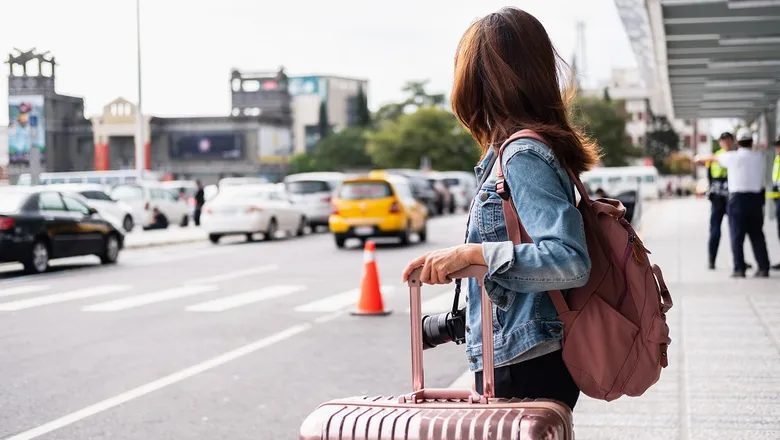 Traveler checking airport transfer options on a phone before departure