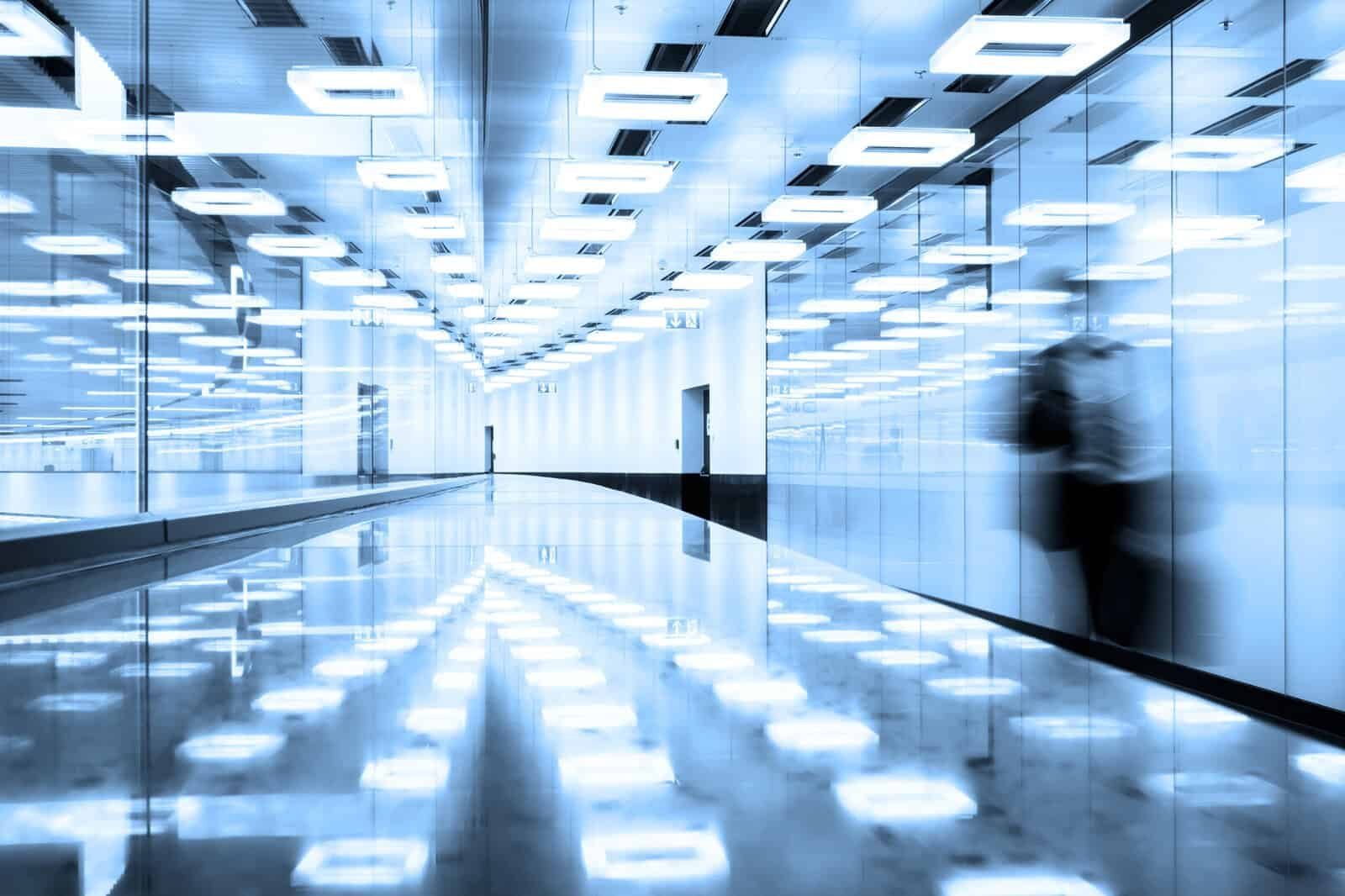Modern airport terminal corridor with travelers walking to their gates