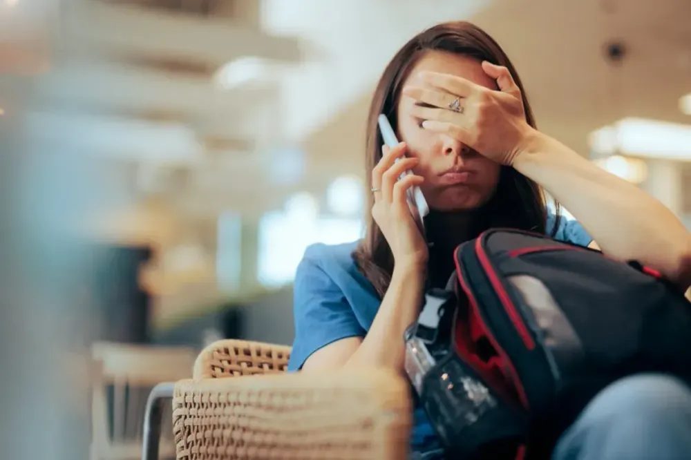 Traveler checking transport options and costs on a phone at the airport