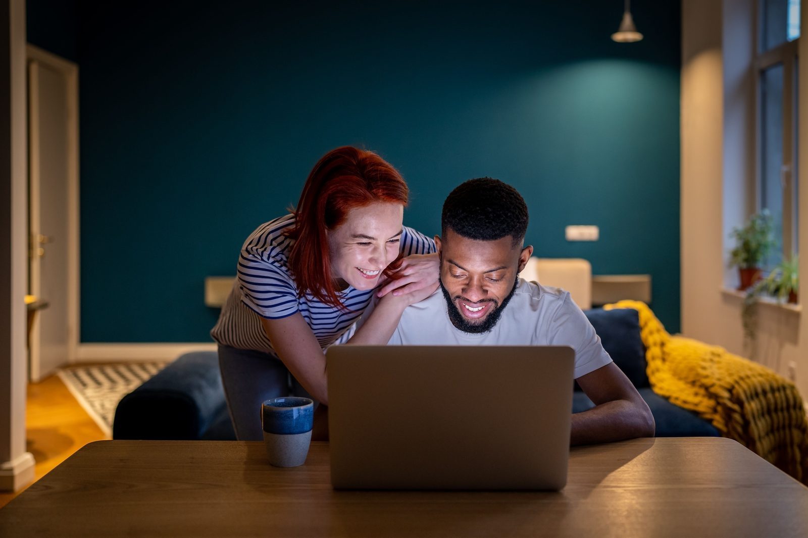 A couple booking flights and planning transport on a laptop