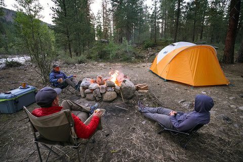 Camping setup with tent and gear laid out at a scenic outdoor campsite