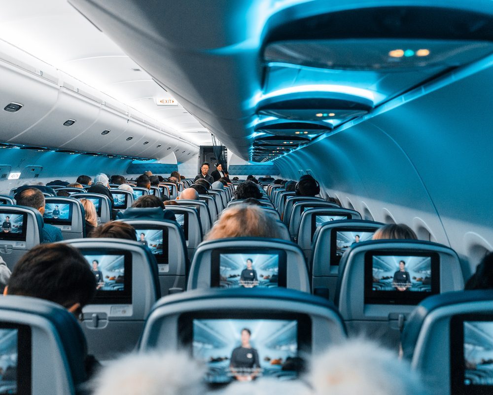 Passengers seated on a plane, illustrating full flights and rebooking decisions