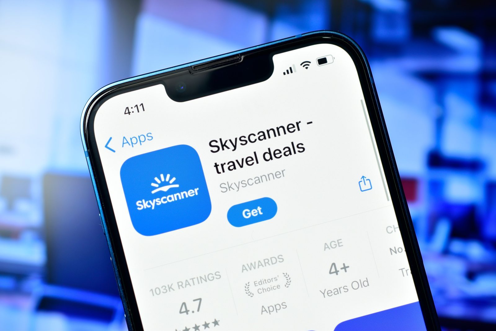 A traveler using a flight search app on a smartphone to compare prices and times