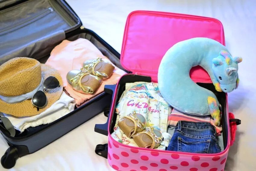 Suitcases and kids' items being packed for a family trip