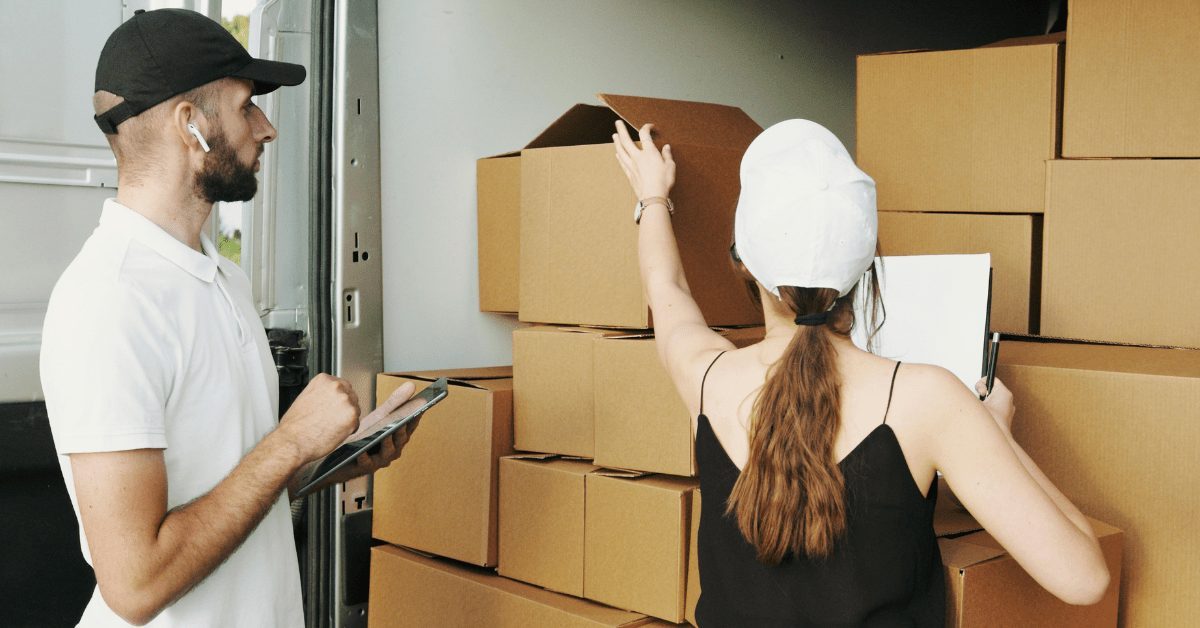 Two people organizing moving boxes with a checklist, symbolizing the planning and allowances involved in PCS and official travel days.