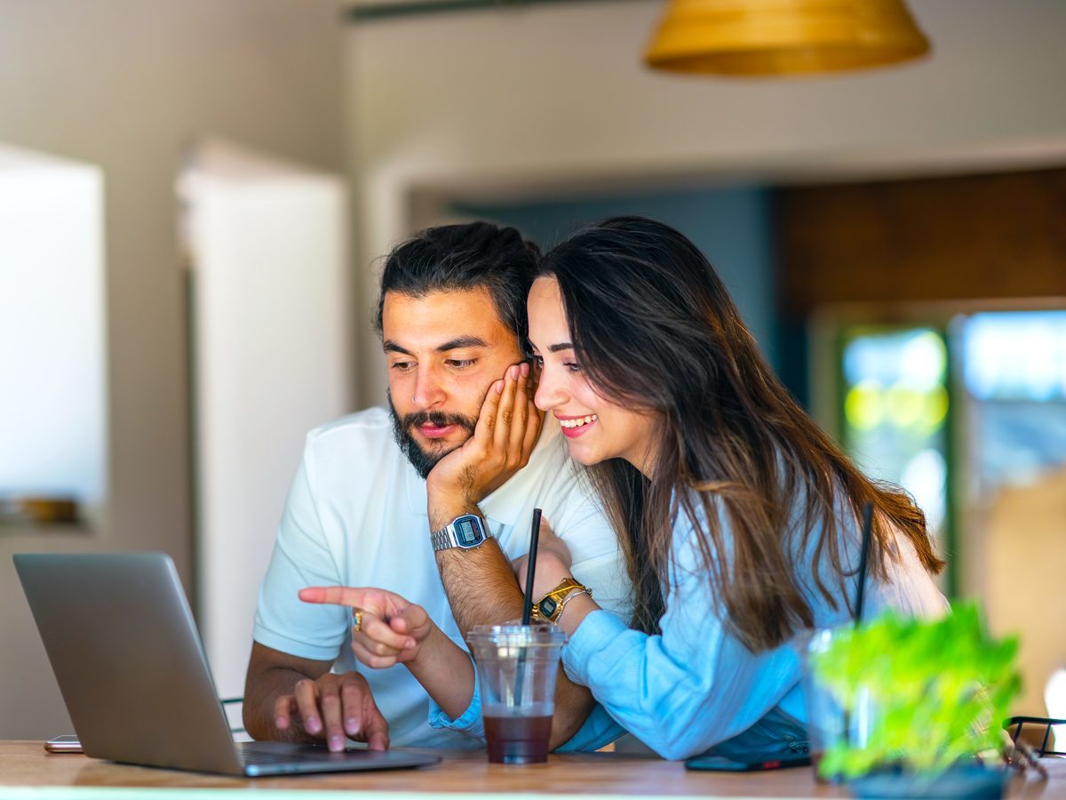 Couple comparing hotel prices on a laptop