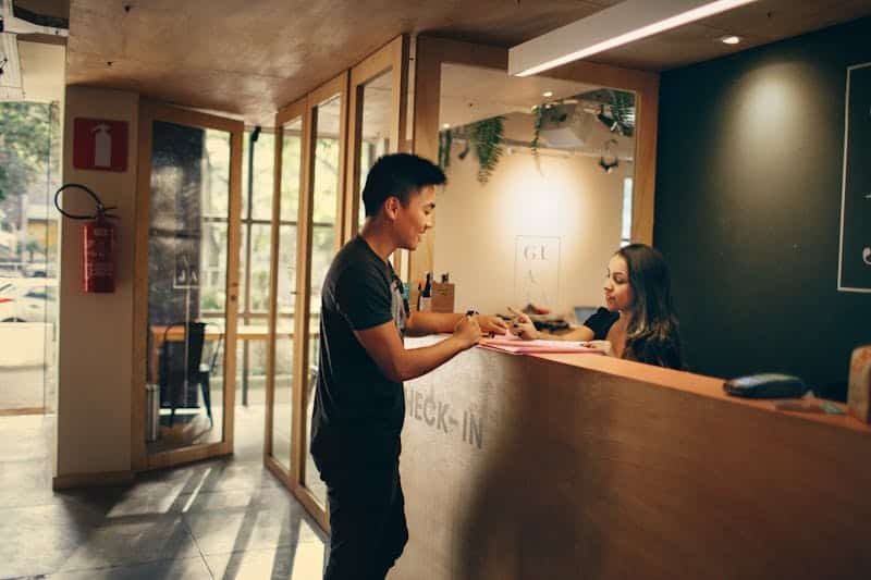 Traveler speaking with hotel front desk staff about luggage storage after checkout