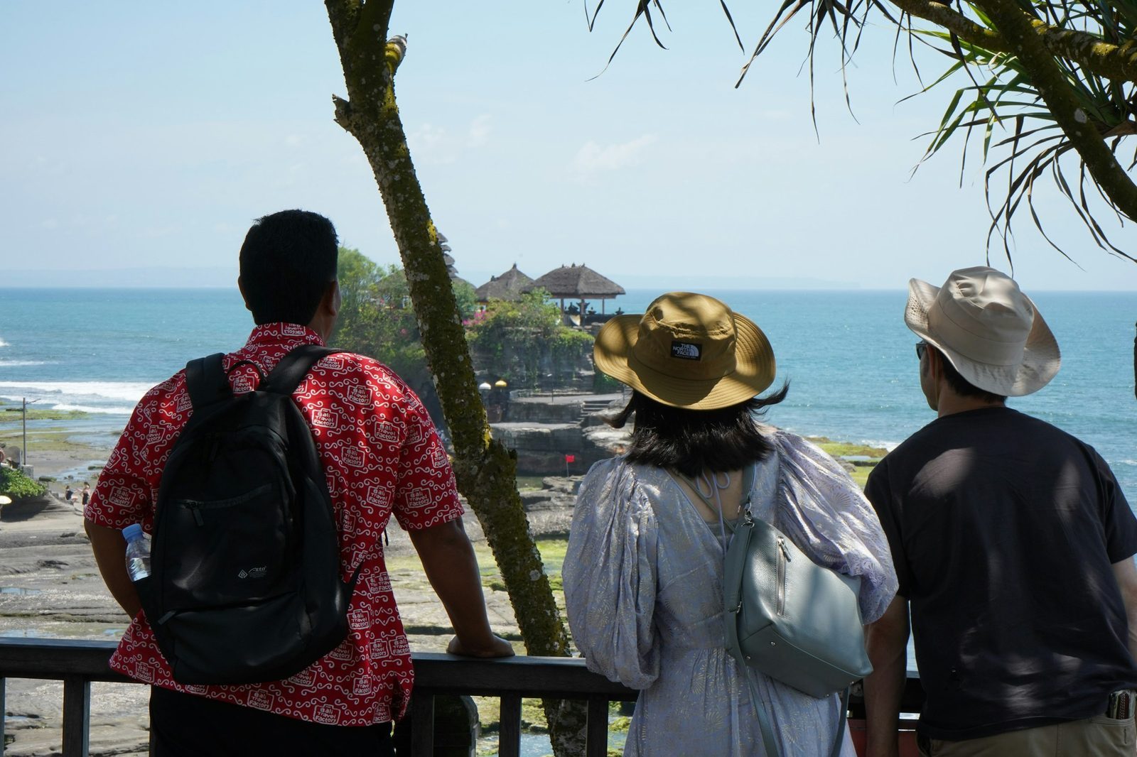 Travelers looking out at the ocean, considering trip plans