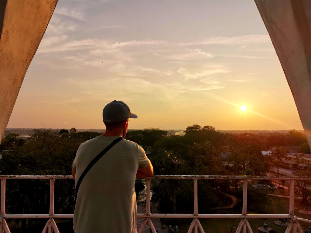 Traveler overlooking a forest at sunset after catching a cheap regional flight, illustrating the value of slow travel once you arrive.