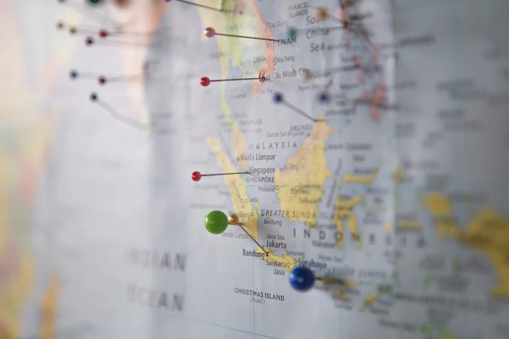 A world map on the wall with pins marking destinations to visit around South East Asia.