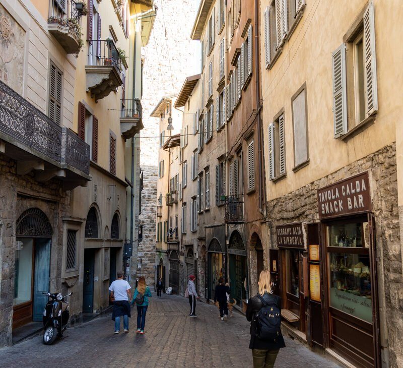 Woman walking the streets in Bergamo, Italy, representing a slower, more intentional travel pace.