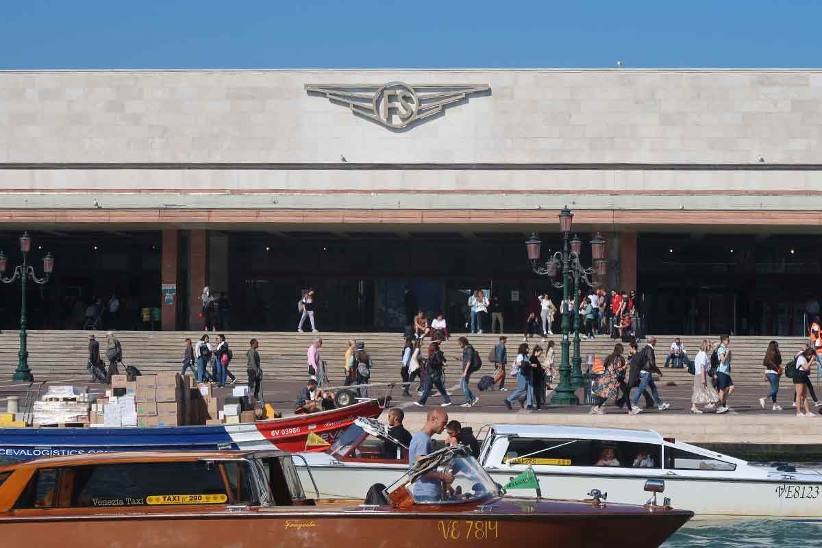Passengers walking through Venice train station platforms, representing a common access point where QR checks may occur